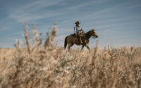Colter Walls poses on a horse in the prairies